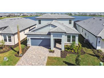 Beautiful two-story home with gray accents, well-manicured landscaping, and a paver driveway at 17245 Savory Mist Cir, Bradenton, FL 34211