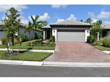 Beautiful single-story home with a brick driveway, well-maintained landscaping, and a two-car garage at 2735 Lavandula Ct, North Port, FL 34289