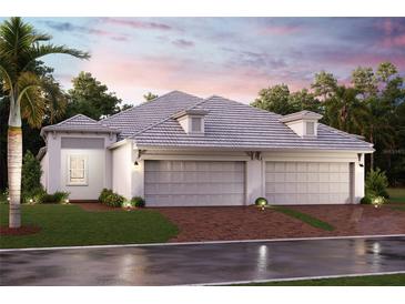 Charming one-story home with a three-car garage, a gray roof, lush landscaping, and brick driveway at 18056 Cherished Loop, Bradenton, FL 34211
