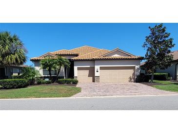 Charming single-story home with a tile roof, brick paver driveway and well-manicured landscaping at 227 Heritage Preserve Run, Bradenton, FL 34212