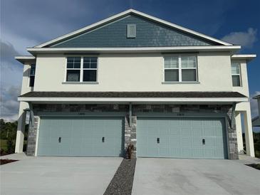 Two-story townhome featuring stone accents and two-car garages at 13978 Emerald Fields Dr, Hudson, FL 34667