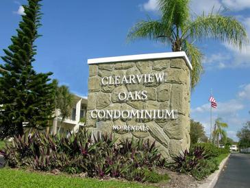 Stone sign for Clearview Oaks Condominium with lush landscaping and blue sky at 4154 57Th N St # 272, Kenneth City, FL 33709