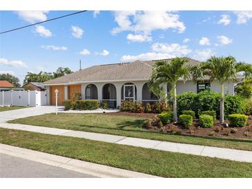 Charming single-story home featuring arched windows, a manicured lawn, and lush landscaping at 567 Whippoorwill Dr, Venice, FL 34293