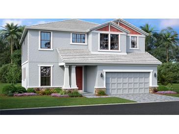 Charming two-story home with a two-car garage, manicured lawn, and tropical landscaping at 7571 Hawkstone Dr, Sarasota, FL 34241
