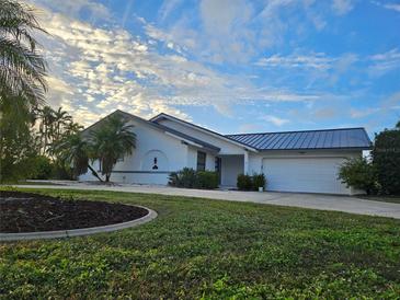 House exterior featuring a metal roof and landscaping at 975 Coronado Dr, Punta Gorda, FL 33950