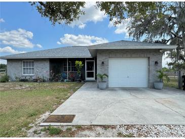 Ranch-style home with a two-car garage and well-maintained landscaping at 40610 State Road 64 E, Myakka City, FL 34251