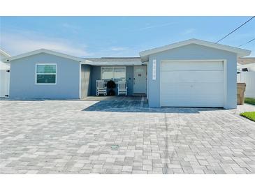 Newly renovated house with a light blue exterior, two-car garage, and paved driveway at 4229 Floramar Ter, New Port Richey, FL 34652