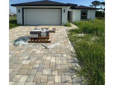 Newly constructed home with driveway and unlandscaped yard at 12122 Clarendon Ave, Port Charlotte, FL 33981