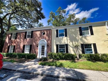 Brick front of two-story building with manicured landscaping at 13824 Orange Sunset Dr # 202, Tampa, FL 33618