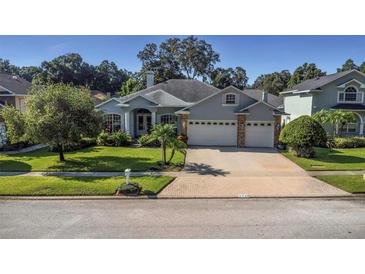 Two-story house with a three-car garage and well-manicured lawn at 2228 Valrico Forest Dr, Valrico, FL 33594