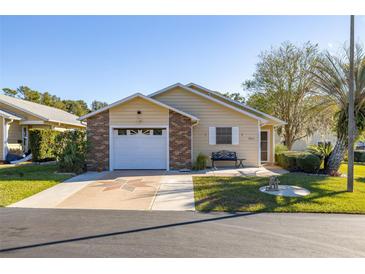 Charming single-story home featuring a brick-accented garage and well-maintained landscaping at 5846 Greenbriar Ct, Zephyrhills, FL 33542