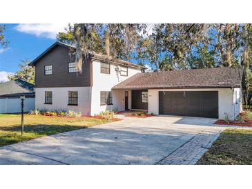 Charming two-story home with a brick and siding exterior and a spacious two-car garage at 407 Belvedere Oval, Temple Terrace, FL 33617
