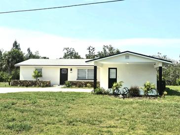 Charming single-story home featuring fresh white paint, black accents, and green yard at 460 Creek Lane Dr, Englewood, FL 34223