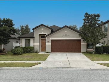 Charming single-story home featuring a well-maintained lawn, two-car garage, and classic architectural details at 675 Hartford Heights St, Spring Hill, FL 34609