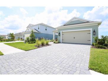 Charming single-Gathering home featuring a two-car garage, a stone driveway, and a well-manicured lawn at 14552 Skipping Stone Loop, Parrish, FL 34219