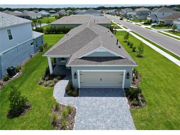 Beautiful single-story home featuring a light-blue exterior, manicured lawn, and a paved driveway leading to a two-car garage at 14552 Skipping Stone Loop, Parrish, FL 34219