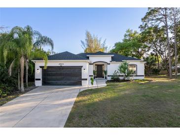 Charming single-story home featuring a well-manicured lawn, covered entry, and attached two-car garage at 2503 Dumont Ln, North Port, FL 34286