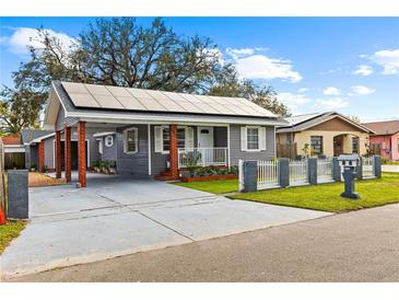 Charming single-story home with grey siding, white trim, solar panels, and a cozy front porch at 2912 W Frierson W Ave, Tampa, FL 33614