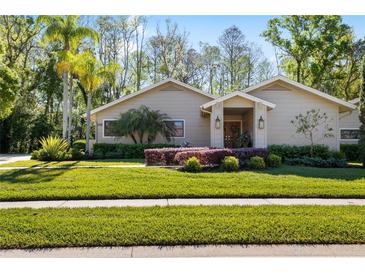 Charming single-story home with lush landscaping and well-manicured lawn at 1025 Royal Troon Ct, Tarpon Springs, FL 34688
