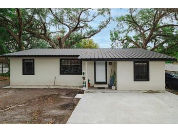 Charming single-story home featuring a metal roof, neutral paint, and minimalist landscaping at 2804 Robinson Rd, Plant City, FL 33565