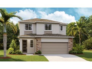 Two-story home featuring stone accents, a two-car garage, neutral colors and well-manicured landscaping at 6014 Jensen View Ave, Apollo Beach, FL 33572