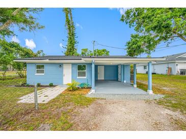 Charming blue single-story home with a covered patio, gravel, and green grass under a clear blue sky at 3728 19Th E St, Bradenton, FL 34208