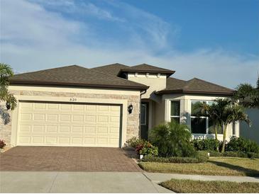 Charming single-Gathering home with a two-car garage, brick driveway, stone accents, and manicured landscaping at 5820 Shorebird Br, Land O Lakes, FL 34638