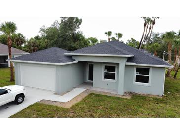 New construction home featuring gray siding, a two-car garage, and a well-manicured lawn at 4098 New Milford St, North Port, FL 34288