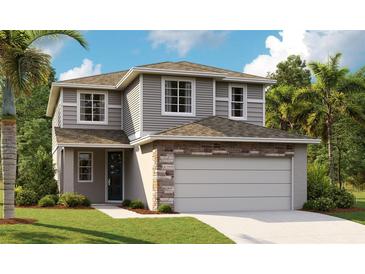 Charming two-story home featuring a two-car garage, stone accents, neutral siding, and well-manicured landscaping at 6034 Jensen View Ave, Apollo Beach, FL 33572
