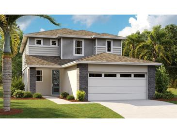 New two-story home featuring modern design, stone accents, neutral color palette, attached two-car garage and manicured front lawn at 6042 Jensen View Ave, Apollo Beach, FL 33572