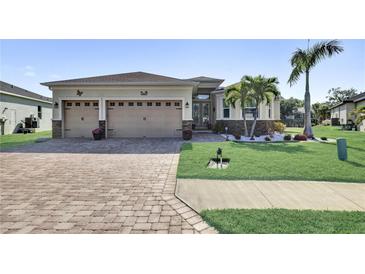 Charming single-story home featuring a two-car garage, landscaped yard with decorative stone and palm trees at 5497 56Th E Ct, Bradenton, FL 34203