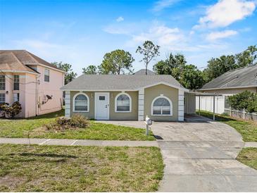 Charming single-story home featuring arched windows, a carport, and a well-maintained front lawn at 4408 W Prescott St, Tampa, FL 33616