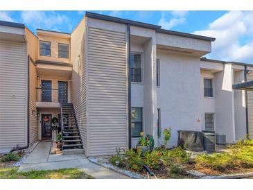 Two-story condo with modern architecture, neutral colors, and a well-maintained front yard and landscaping at 5151 Puritan Cir # 1022, Tampa, FL 33617