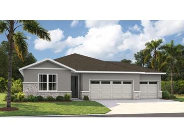 Charming one-story home featuring a three-car garage, gray stucco, and stone veneer accents at 9211 Players Dr, Weeki Wachee, FL 34613