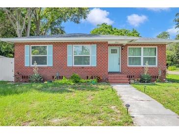 Charming single-story brick home featuring a manicured front yard, light blue shutters, and a light blue front door at 2601 Upton S St, Gulfport, FL 33711
