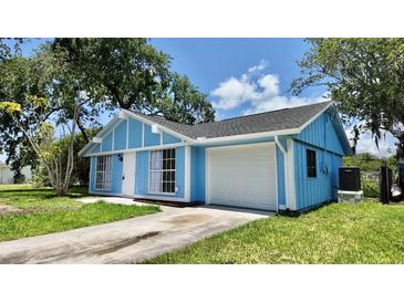 Charming home with bright blue siding, white trim, attached garage, and a well-manicured lawn at 4546 Ontario Dr, New Port Richey, FL 34652