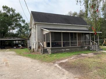 Quaint house exterior with screened porch and mature trees at 115 W Alsobrook St, Plant City, FL 33563