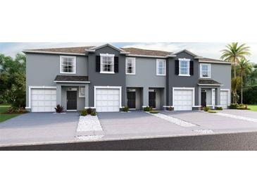 Charming exterior of townhomes featuring individual garages and well-kept landscaping at 5108 Captain Davis Dr, Wimauma, FL 33598
