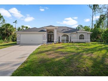 Newly built home with gray exterior, two-car garage, and well-manicured lawn at 2510 Sheila Ln, North Port, FL 34286
