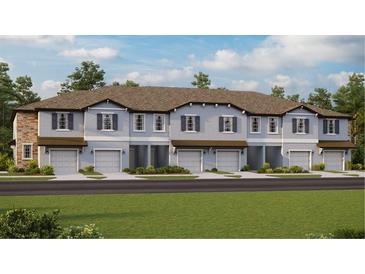 Contemporary townhome community with attached garages and well-manicured lawns at 10439 Lavender Aster Trl, San Antonio, FL 33576