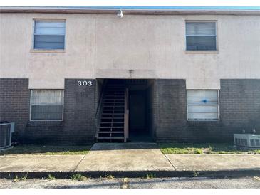 Exterior view of a light beige building with dark brown brick accents at 303 E Wellington Ct # 59, Tampa, FL 33604