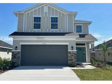Two-story home featuring stone accents, a two-car garage, and neutral-colored siding at 7002 162Nd E Pl, Parrish, FL 34219