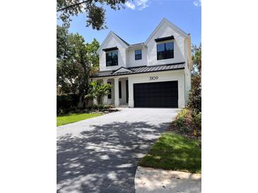 Beautiful two story home with a black garage door and brick driveway at 3109 W Knights Ave, Tampa, FL 33611