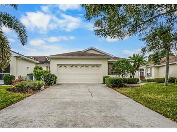 House exterior featuring a driveway, garage, and well-manicured landscaping at 2221 Nantucket Dr # 54, Sun City Center, FL 33573