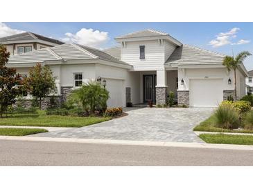 Beautiful single-Gathering home with a well-manicured lawn and two-car garage, showing great curb appeal at 17721 Roost Pl, Lakewood Ranch, FL 34211