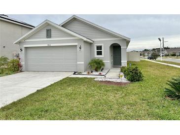 Single-story home with a two-car garage and well-maintained lawn at 7855 Davie Ray Dr, Zephyrhills, FL 33540