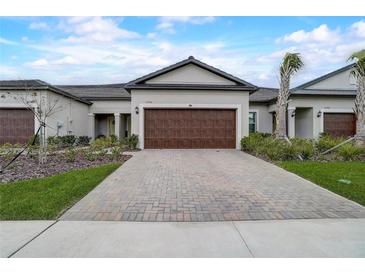 Modern home with a brick driveway and a two-car garage at 31396 Cabana Rye Ave, San Antonio, FL 33576