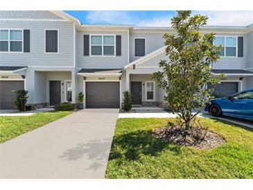 Modern two-story townhouse with gray siding and landscaping at 9658 Sweetwell Pl, Riverview, FL 33569