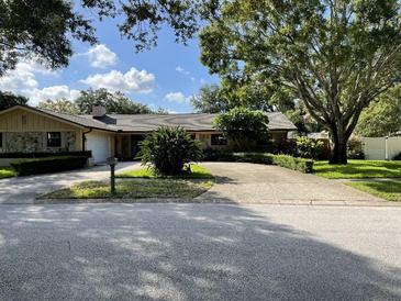 House exterior features stone accents and a well-maintained lawn at 2275 Willowbrook Dr, Clearwater, FL 33764