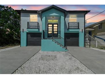 Two-story home featuring a dual-entry design with black garage doors and matching railings at 3351 Fernleaf Dr, Hernando Beach, FL 34607